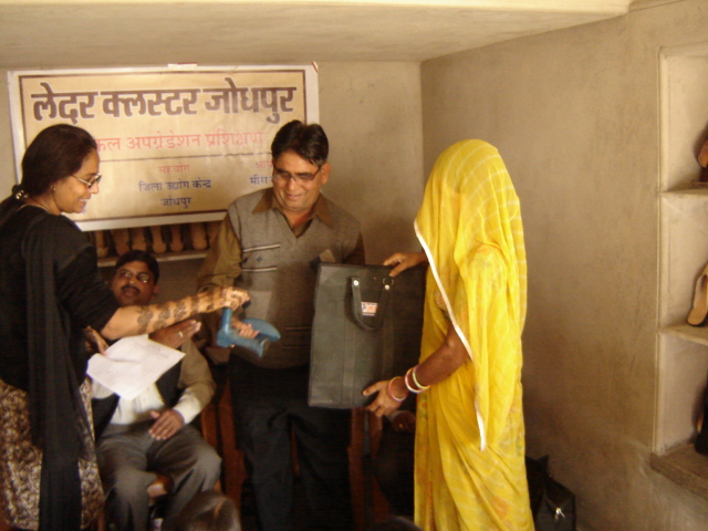 Patron and Director Asha Bothra distributing leather craft toolkits to rural women