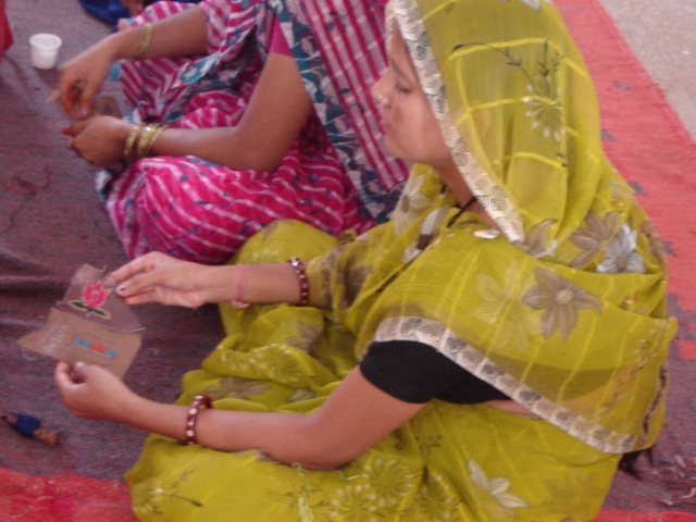 Rural woman artisan inspecting floral leather embroidery